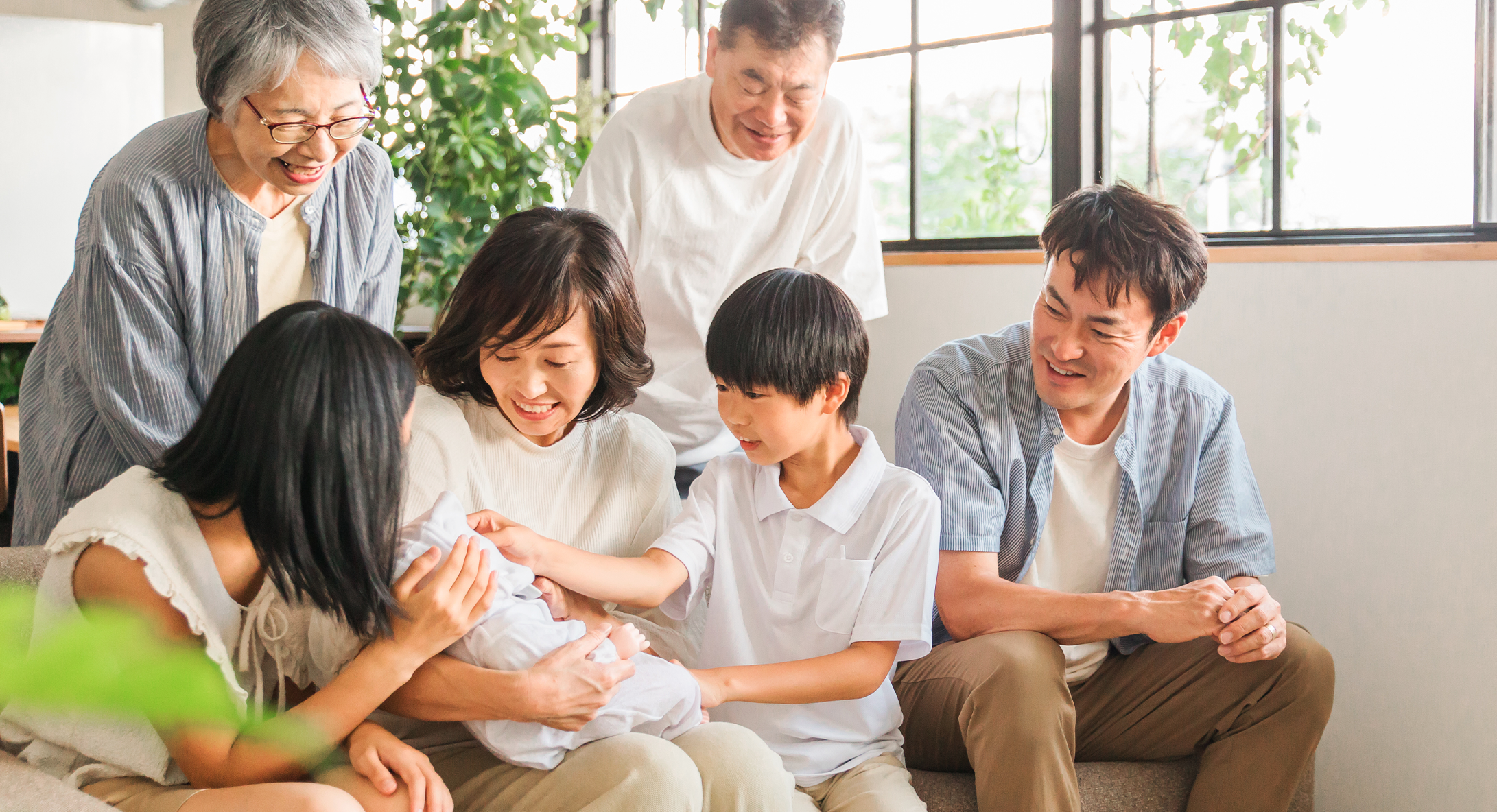 家族がソファーに座って微笑んでいる